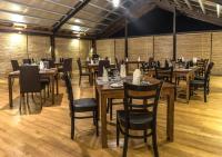 Un comedor con mesas y sillas de madera. en Manthila Hotel, en Anuradhapura