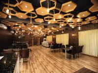 ein Restaurant mit Tischen und Stühlen und einer Decke mit Lichtern in der Unterkunft Shinjini Resort in Mandarmani