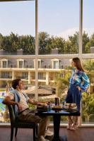 a man and woman sitting at a table in front of a window at Renaissance Cairo Mirage City Hotel in Cairo