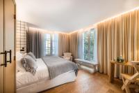 1 dormitorio con 1 cama y algunas ventanas en Grand Hotel Soleil d&#39;Or, en Megève