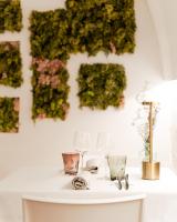 een tafel met glazen en planten tegen een muur bij Bed & Breakfast Locanda Trani in Trani