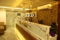 un vestíbulo con un mostrador con relojes en la pared en Grand Tamim Hotel, en Mangalore