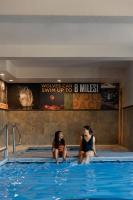 two women sitting on the edge of a swimming pool at Gray Wolf Inn &amp; Suites in West Yellowstone