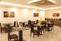 Un restaurante con mesas y sillas en una sala. en GOODWILL HOTEL, en Nueva Delhi