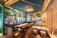 un restaurante con una fila de mesas y sillas en The All - Suite Pentacity Hotel Balikpapan, en Balikpapan