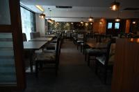 a dining room with tables and chairs and lights at The Budhil Park in Visakhapatnam