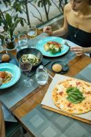 Una donna seduta a un tavolo con una pizza di Avantgarde Urban Levent a Istanbul