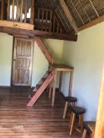 a room with a wooden staircase and two stools at Soanala in Moramanga