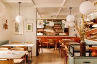 um restaurante com mesas e cadeiras e uma escada em Locke de Santa Joana em Lisboa