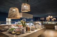 a buffet line with bowls of food and lights at Falkensteiner Hotel Park Punat in Punat