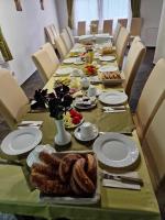 Una mesa larga con platos y comida encima. en Senyői Vendégház, en Bózsva