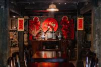 ハザンにあるHa Giang Xanh Retreat - Trekking, Tour, Motorbike Rentalのテーブルと赤い装飾のあるダイニングルーム