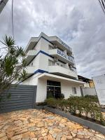 Un edificio blanco con un cartel azul. en Hotel Brasil Real, en Mariana