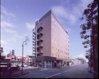 Un edificio alto en una calle de la ciudad con una farola. en Washington R&amp;B Hotel Kumagaya Ekimae, en Kumagaya