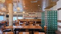 un ristorante con tavoli e sedie in legno e un bar di Jauri Resort a Kemijärvi