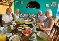 a group of people sitting around a table with food at Beachfront Paradise Boutique Hotel - Alebrijes Jacuzzi Villa in Playa Agua Blanca
