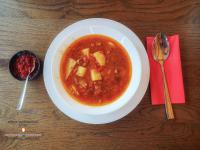 Een kom soep op tafel met een rood servet. bij Domeniul Magura in Poduri