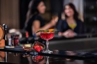 Una bebida en una copa de martini con fresas en una barra. en Marriott Hotel Al Forsan, Abu Dhabi, en Abu Dabi