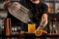 Un hombre está preparando una bebida en una mesa. en Marriott Hotel Al Forsan, Abu Dhabi, en Abu Dabi