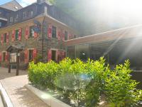 ein Gebäude mit roten Fensterläden und Pflanzen vorne in der Unterkunft Das kleine Gasthaus in Kamp-Bornhofen