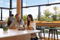 Un hombre y una mujer sentados en una mesa en un restaurante. en Hotel Champlain Burlington, Curio Collection by Hilton, en Burlington