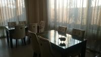 a dining room with a glass table and chairs at LivingGreen B&amp;B in Luodong