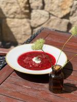 Een bord rode soep op een tafel met een vaas. bij Piastowski26 in Jelenia Góra