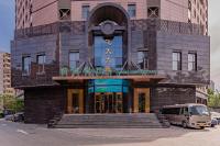 ein Gebäude mit einem Van davor in der Unterkunft Beijing Feitian Hotel in Peking