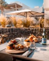 ein Tisch mit zwei Tellern Essen und einer Flasche Wein in der Unterkunft Radisson Blu Zaffron Resort, Santorini in Kamari