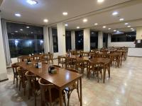 um restaurante com mesas e cadeiras de madeira e janelas em Hotel Valle Sul em Registro