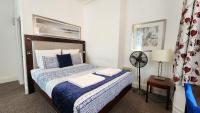 a bedroom with a bed with blue and white pillows at Gatwick Castle B&B in Horley