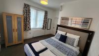 a bedroom with a bed with blue and white pillows at Gatwick Castle B&B in Horley