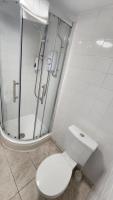 a white bathroom with a toilet and a shower at Gatwick Castle B&B in Horley