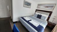 a bedroom with a bed with blue and white sheets at Gatwick Castle B&B in Horley