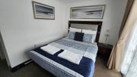 a bedroom with a bed with blue and white blankets and pillows at Gatwick Castle B&B in Horley