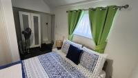 a bedroom with a bed with a green curtain at Gatwick Castle B&B in Horley