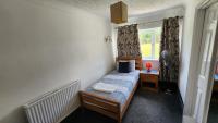 a small bedroom with a bed and a window at Gatwick Castle B&B in Horley