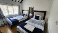 a bedroom with two beds with blue and white at Gatwick Castle B&B in Horley