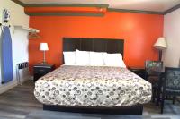 Un dormitorio con una cama con una pared naranja. en Lambert Inn, en Whittier