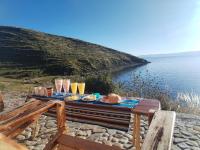 uma mesa com copos e comida ao lado da água em Ecolodge INTI WATA em Comunidad Challapampa