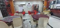 a dining room with tables and chairs and people at a counter at SIESTA HOTEL in Djibouti