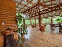 a pavilion with a bench and tables and a plant at Arenal Rústic Lodge in Fortuna