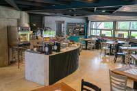 a restaurant with a counter and some tables and chairs at Resort Špindl in Špindlerův Mlýn