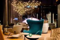 Una habitación con sillas y mesas y una lámpara de araña. en Motel One Leipzig-Post, en Leipzig