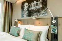 a bedroom with a bed with a poster on the wall at Motel One Salzburg-Mirabell in Salzburg