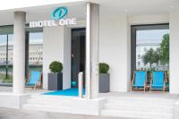 a motel one sign in front of a building with blue chairs at Motel One Salzburg-Mirabell in Salzburg