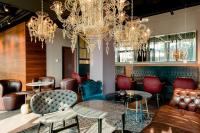 a lobby with tables and chairs and chandeliers at Motel One Salzburg-Mirabell in Salzburg