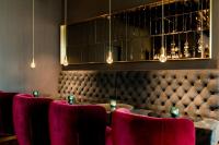 a dining room with a table and red chairs at Motel One Salzburg-Mirabell in Salzburg