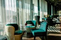 a waiting room with chairs and tables and windows at Motel One Salzburg-Mirabell in Salzburg