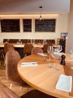 NoaillanにあるManoir Belle Fontaineのレストランにあるワイングラスが置かれた大きな木製のテーブル